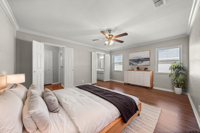 bedroom with baseboards, multiple windows, visible vents, and wood finished floors