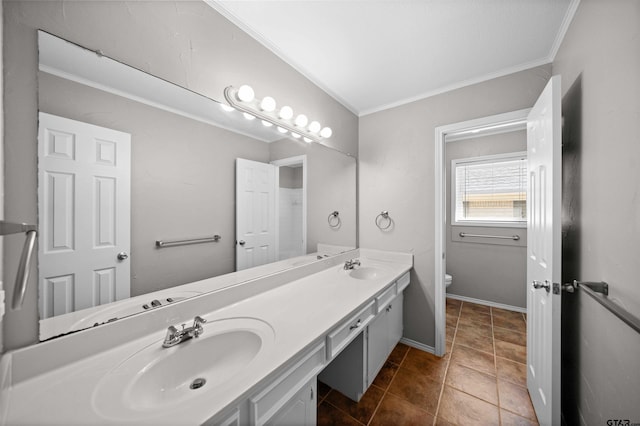 full bathroom featuring toilet, crown molding, double vanity, and a sink