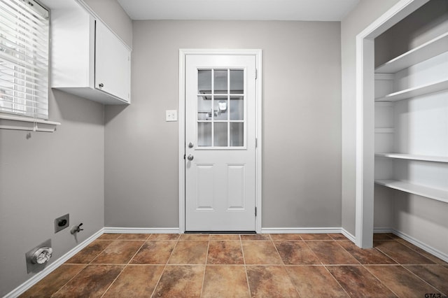 laundry area with gas dryer hookup, cabinet space, baseboards, and hookup for an electric dryer