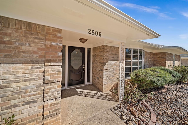 entrance to property featuring brick siding