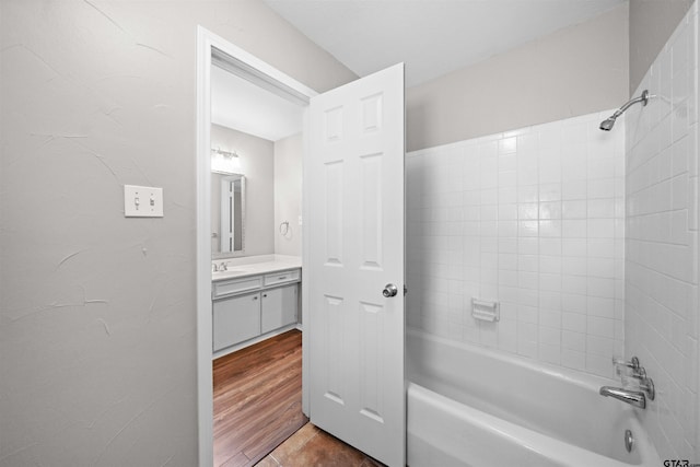 full bath with tub / shower combination, wood finished floors, and vanity