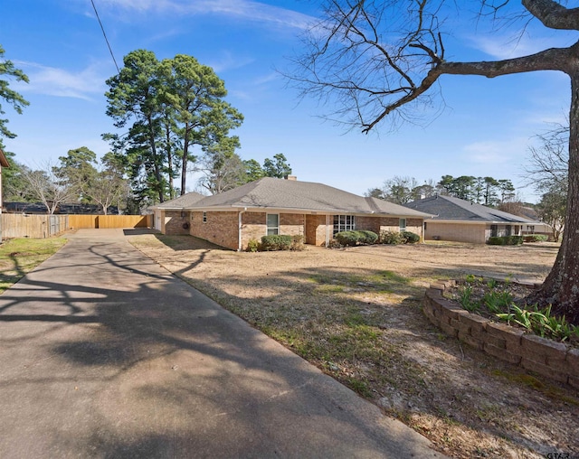 view of front of home with brick siding, fence, and a chimney