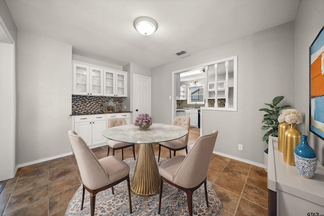 dining space featuring baseboards and visible vents