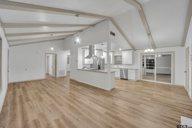 kitchen with stainless steel appliances, kitchen peninsula, wall chimney exhaust hood, white cabinetry, and light hardwood / wood-style flooring