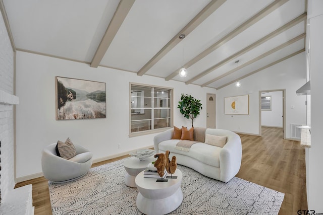 living room featuring a brick fireplace, light wood-type flooring, and lofted ceiling with beams