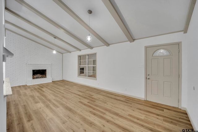 unfurnished living room featuring light wood-type flooring, vaulted ceiling with beams, and a fireplace