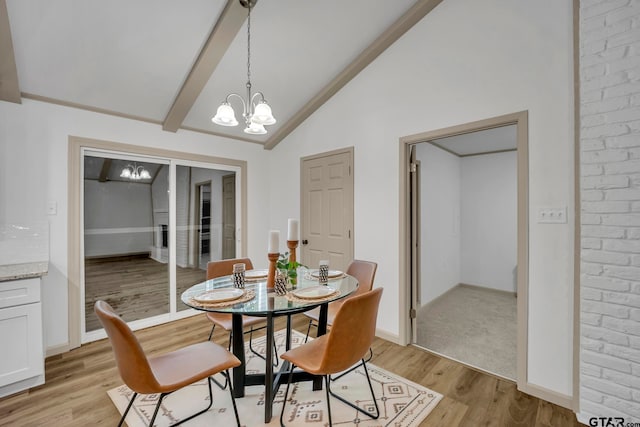 dining space with light wood-type flooring, a notable chandelier, and vaulted ceiling with beams