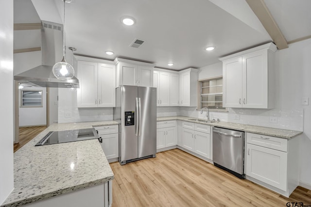 kitchen with white cabinets, stainless steel appliances, hanging light fixtures, and light hardwood / wood-style floors