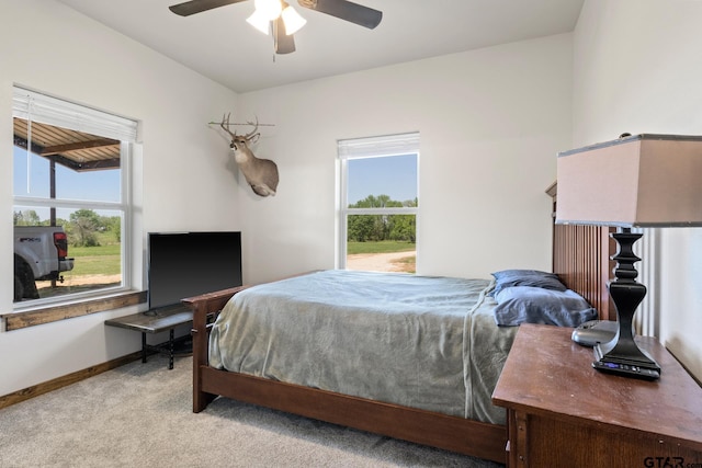 bedroom featuring a ceiling fan, carpet flooring, baseboards, and multiple windows