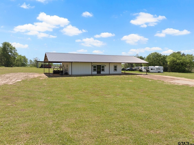 country-style home with dirt driveway, a front lawn, and metal roof