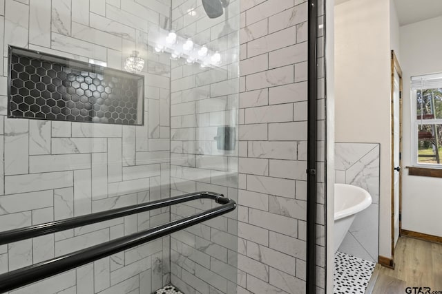 full bathroom featuring a shower stall, wood finished floors, and a soaking tub