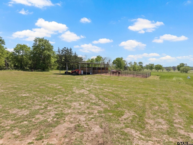 view of yard with a rural view, an exterior structure, and an outbuilding