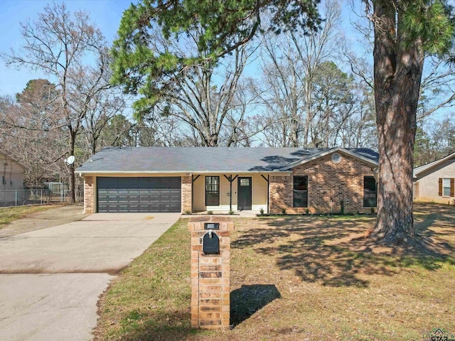 ranch-style home featuring brick siding, a front lawn, fence, driveway, and an attached garage