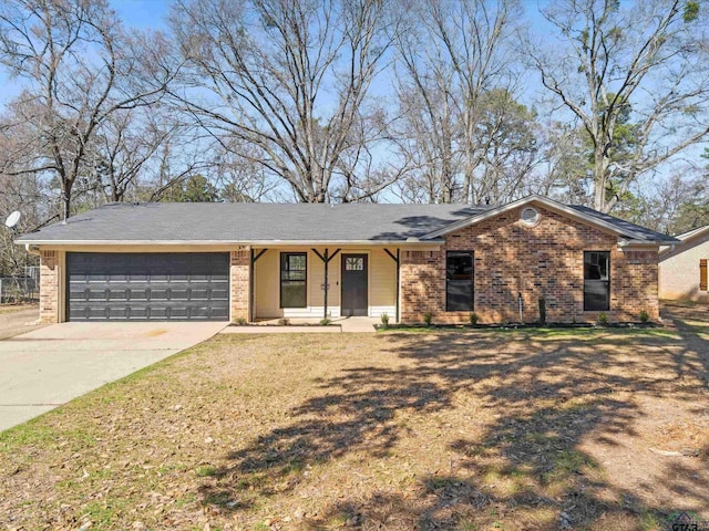 ranch-style home with brick siding, an attached garage, concrete driveway, and a front lawn