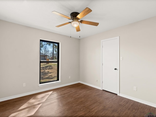 spare room featuring dark wood-type flooring, baseboards, and ceiling fan