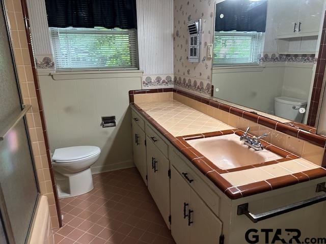 504 Mt Sylvan, Lindale, TX 75771 - full bathroom featuring toilet, vanity, wallpapered walls, and tile patterned flooring