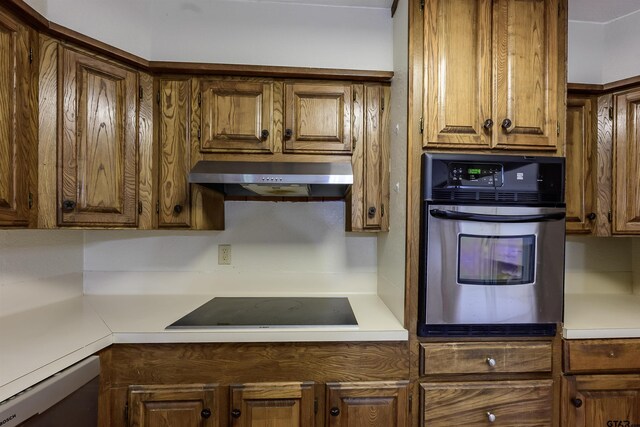 16850 Rainbow Ridge Cir, Tyler, TX 75707 - kitchen featuring oven, black electric stovetop, under cabinet range hood, dishwashing machine, and light countertops