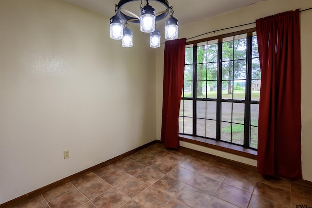 16850 Rainbow Ridge Cir, Tyler, TX 75707 - spare room featuring a chandelier, baseboards, and dark tile patterned floors