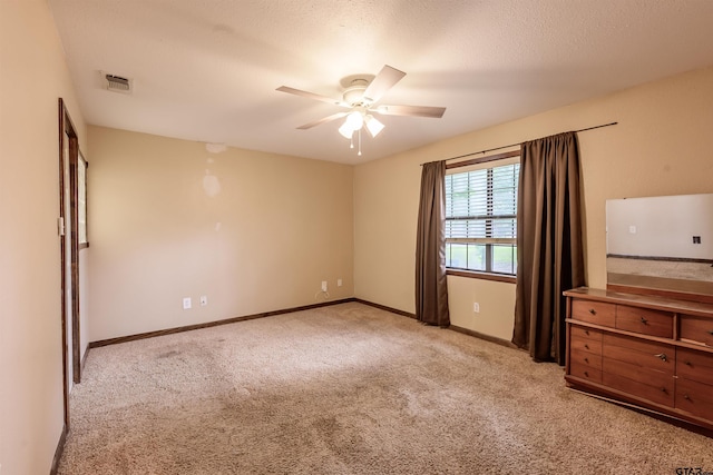 16850 Rainbow Ridge Cir, Tyler, TX 75707 - unfurnished bedroom featuring light colored carpet, baseboards, ceiling fan, and a textured ceiling