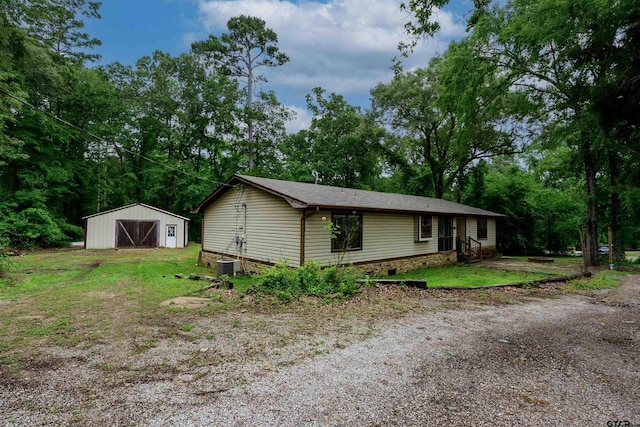 16850 Rainbow Ridge Cir, Tyler, TX 75707 - view of front facade with a detached garage, an outbuilding, a pole building, and central AC unit