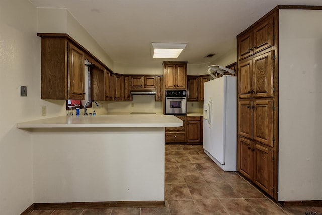 16850 Rainbow Ridge Cir, Tyler, TX 75707 - kitchen featuring white fridge with ice dispenser, stainless steel oven, a peninsula, light countertops, and black electric stovetop