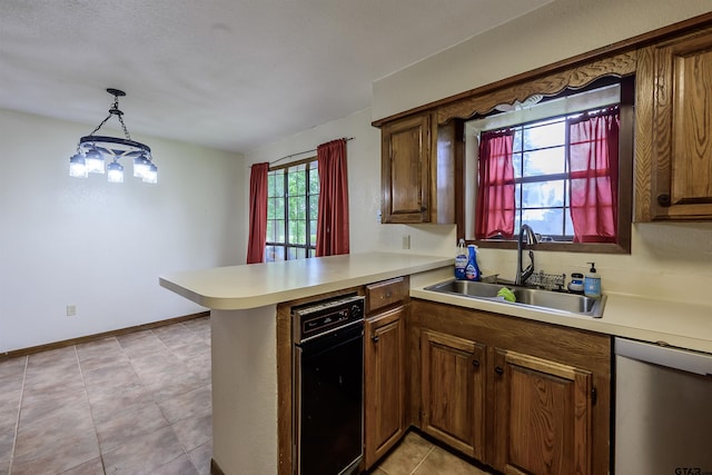 16850 Rainbow Ridge Cir, Tyler, TX 75707 - kitchen with a sink, dishwasher, a peninsula, light countertops, and brown cabinetry