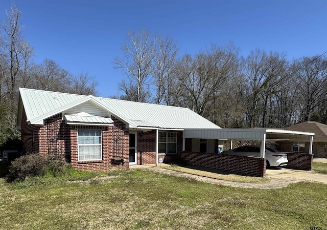 view of front of property with driveway, a front lawn, metal roof, an attached carport, and brick siding