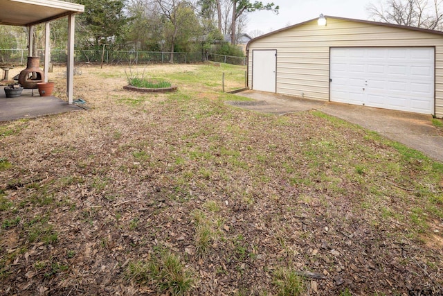 view of yard featuring an outbuilding, fence, and a garage