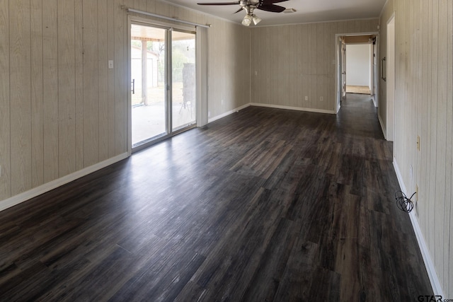 unfurnished room with baseboards, dark wood-type flooring, and a ceiling fan