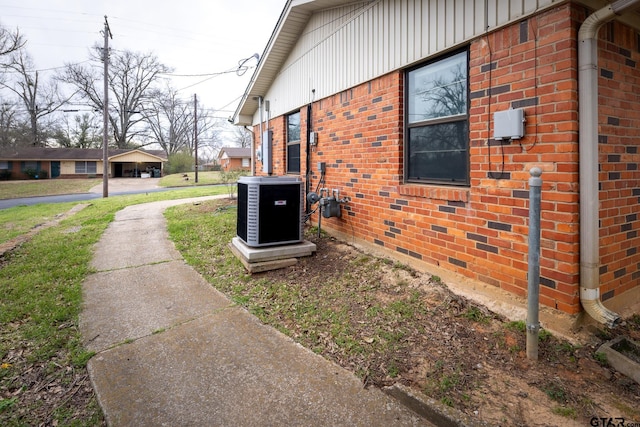 view of property exterior featuring brick siding and central AC unit