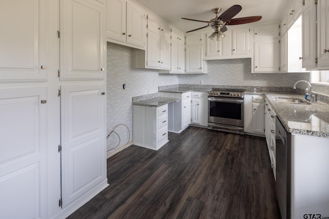 kitchen with light stone counters, white cabinets, stainless steel appliances, and ceiling fan