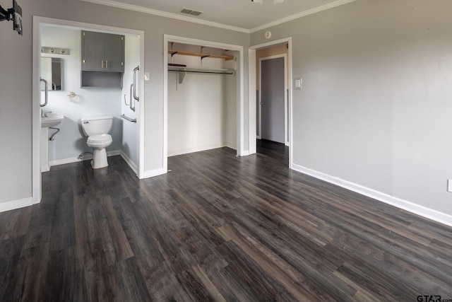 unfurnished bedroom featuring dark wood-style floors, visible vents, baseboards, a closet, and crown molding