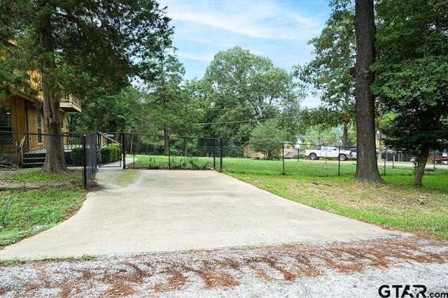 327 Dailey Rd, Crockett, TX 75835 - view of patio / terrace featuring a gate, concrete driveway, fence, and view of scattered trees