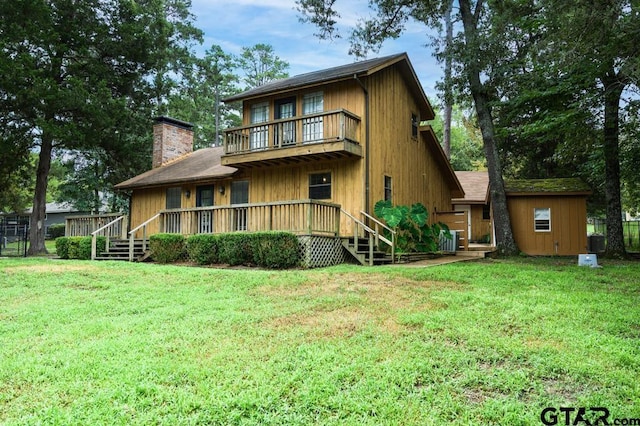 327 Dailey Rd, Crockett, TX 75835 - rear view of house featuring a balcony, a lawn, and a chimney