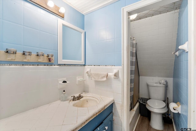 7928 Fm 127, Mount Pleasant, TX 75455 - bathroom featuring tile walls, toilet, a shower with curtain, vanity, and wood finished floors