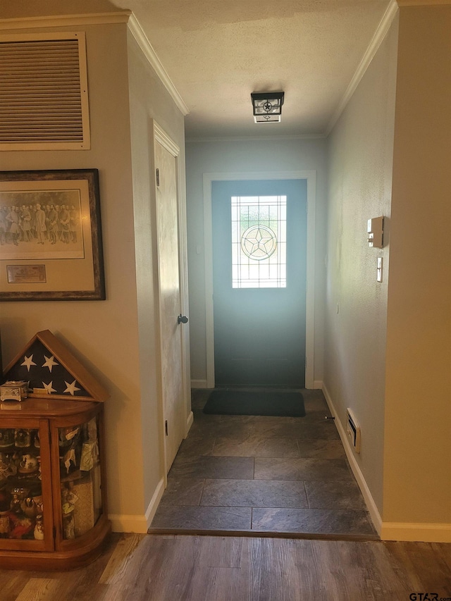 entryway featuring dark wood-type flooring, a textured ceiling, and ornamental molding