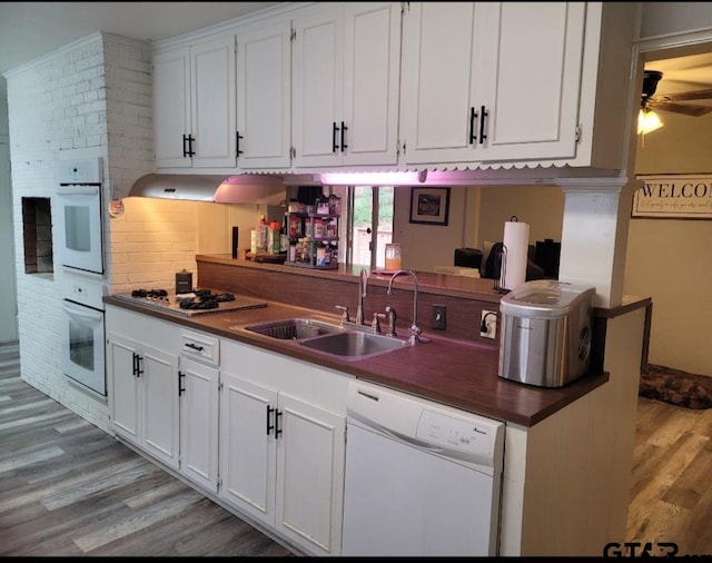 kitchen with white cabinets, white appliances, and light hardwood / wood-style flooring