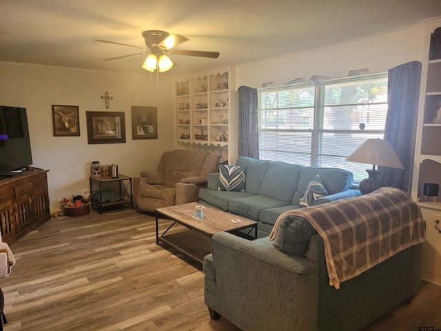 living room with ornamental molding, wood-type flooring, and ceiling fan