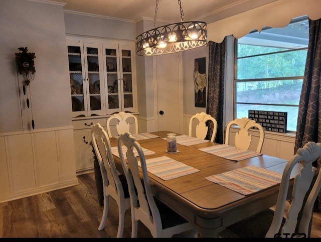 dining area featuring dark wood-type flooring and crown molding