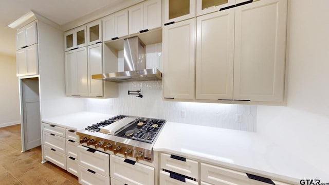 8016 Crooked Trl, Tyler, TX 75703 - kitchen with wall chimney exhaust hood, light countertops, white cabinets, stainless steel gas stovetop, and glass insert cabinets