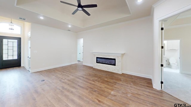 8016 Crooked Trl, Tyler, TX 75703 - unfurnished living room with a tray ceiling, ceiling fan, a glass covered fireplace, light wood-type flooring, and recessed lighting