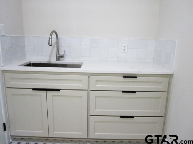 interior space featuring backsplash and sink