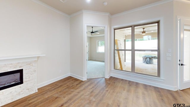 8016 Crooked Trl, Tyler, TX 75703 - unfurnished living room featuring ornamental molding, ceiling fan, wood finished floors, and a stone fireplace