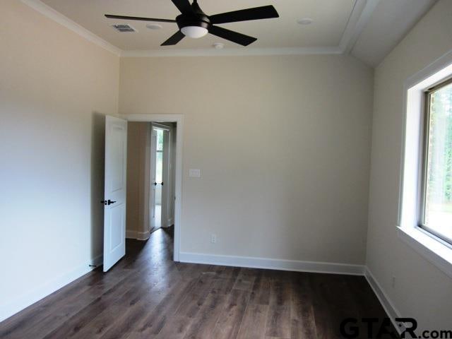 empty room featuring ornamental molding, a healthy amount of sunlight, dark hardwood / wood-style floors, and ceiling fan