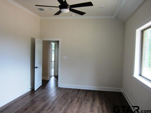 8016 Crooked Trl, Tyler, TX 75703 - empty room featuring crown molding, dark wood finished floors, and ceiling fan