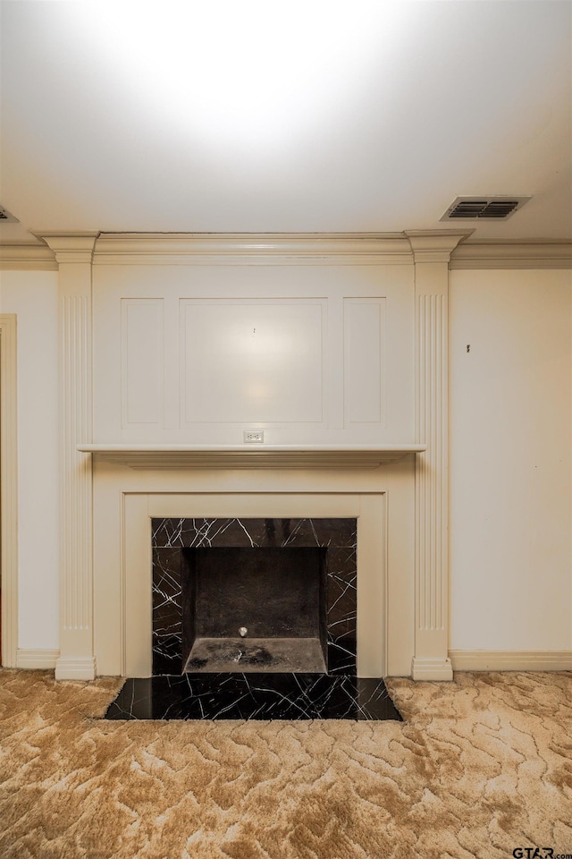 interior details featuring carpet floors, crown molding, and a tiled fireplace