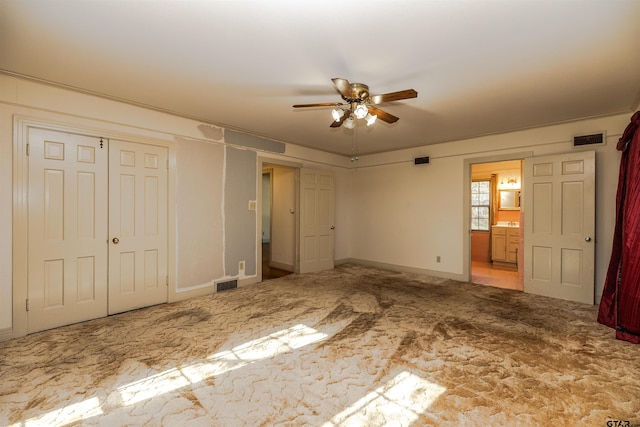 unfurnished bedroom with ceiling fan and connected bathroom