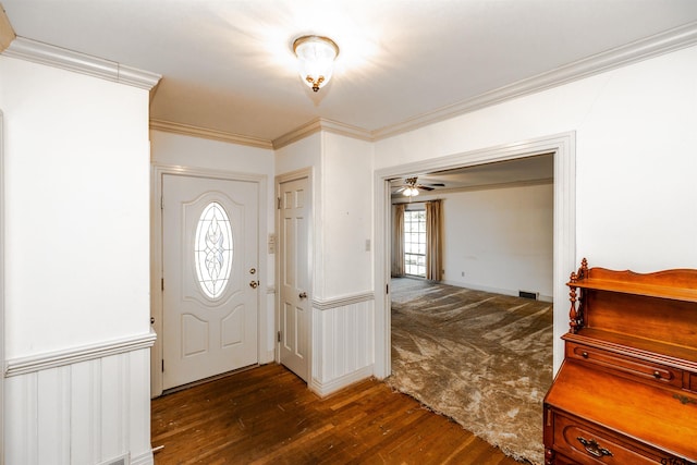 foyer featuring ceiling fan, ornamental molding, and dark wood-type flooring