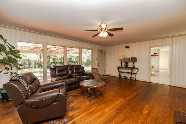 living room featuring ceiling fan, dark hardwood / wood-style flooring, and ornamental molding