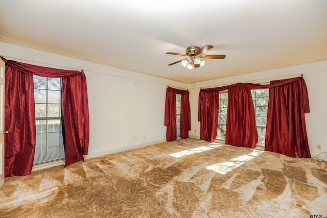 unfurnished room with ceiling fan, crown molding, carpet, and a healthy amount of sunlight